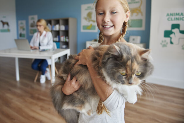携带一个女孩和她的猫的画像腰部以上医学医生