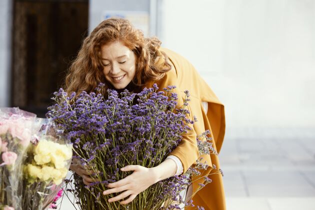 成人带着一束春花在户外微笑的女人开花花水平