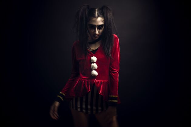 肖像一个穿着天鹅绒红色服装 脸上涂着可怕化妆品的女人站着恐怖年轻服装