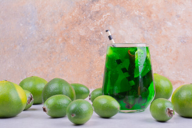 食物一杯绿色饮料 配上蜜饯和蜜柑热带素食水果