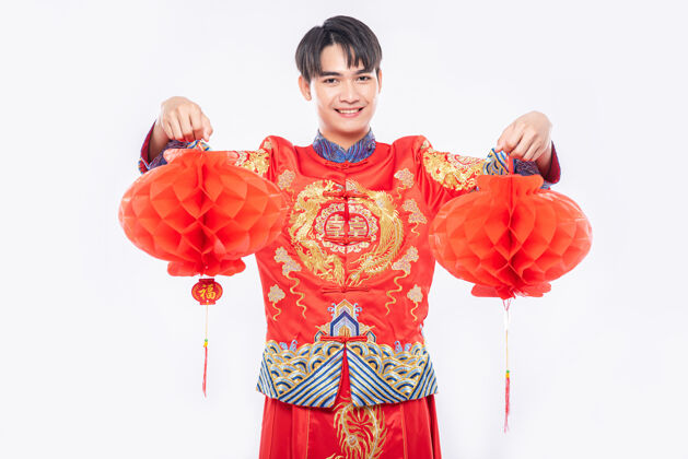 传统穿旗袍西服的男人在过年的时候到他店里装饰红灯文化中国文化旗袍