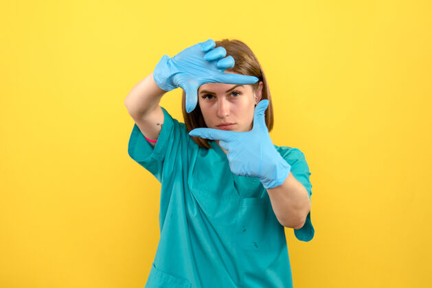 人黄色空间上戴着蓝色手套的女医生的前视图蓝色脸人