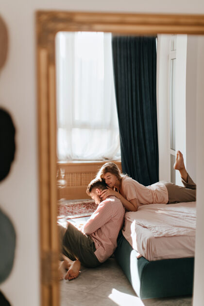 夫妇镜子里的照片是躺在床上的女孩当年轻人坐在地板上时 一位温柔的女士拥抱着他男性男朋友公寓