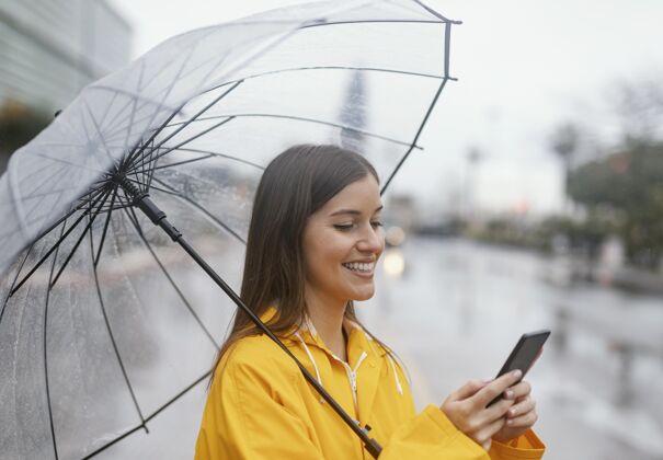 外观拿伞的女人用手机发型年轻年轻