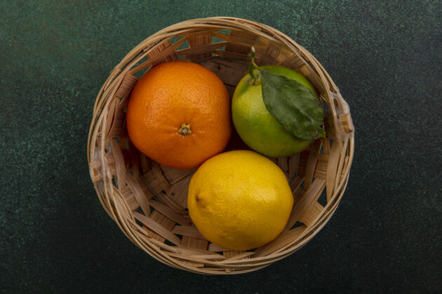 柠檬顶视图橙色与柠檬和柠檬在绿色的背景篮子顶部橙色景观