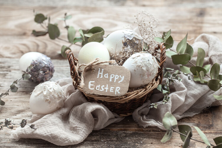 符号漂亮的复活节彩蛋放在一个用干花装饰的篮子里复活节快乐愿望静物装饰