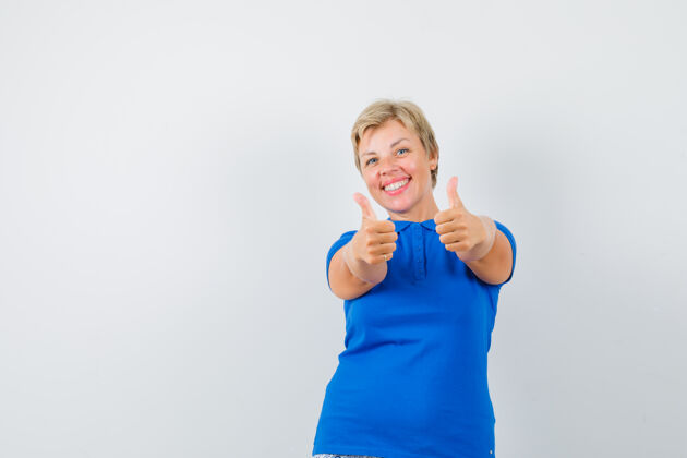 肖像穿蓝色t恤的成熟女人向上竖起大拇指 看起来很开心脸拇指成熟
