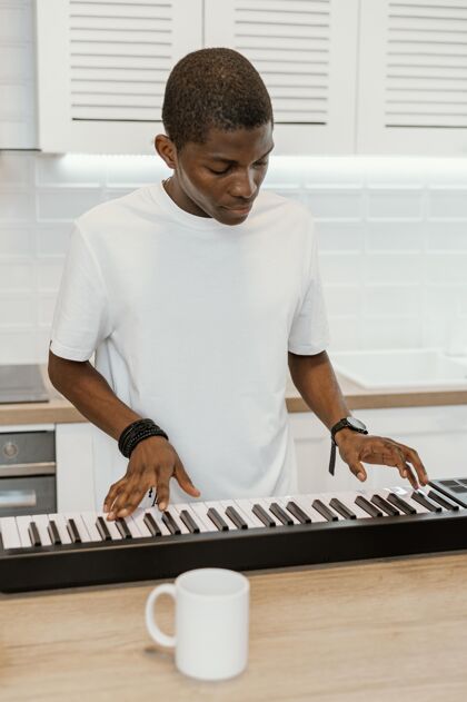 人才男音乐家在家玩电子键盘的正面图表演创意音乐家