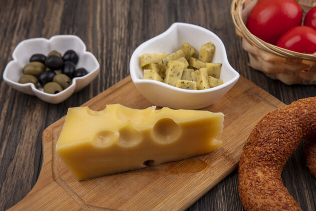 金色木制厨房板上碗上有奶酪片的奶酪顶视图 木制背景上碗上有橄榄食物木板乡村风味