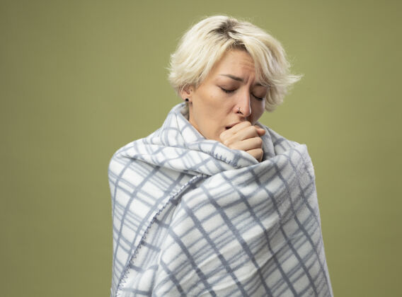 短裤生病的不健康的女人 短发 裹着毯子 站在轻墙边咳嗽不健康感情女人