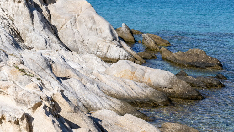 观点爱琴海沿岸有岩石在水面上 蓝色的海水 希腊海景度假村沙