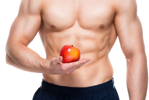 运动员身材完美的年轻人手里拿着红苹果素食帅哥胸部