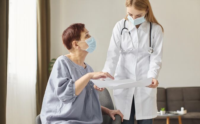 成熟老年患者带着医用口罩和科维德康复中心的女医生一起看结果冠状病毒治疗面罩