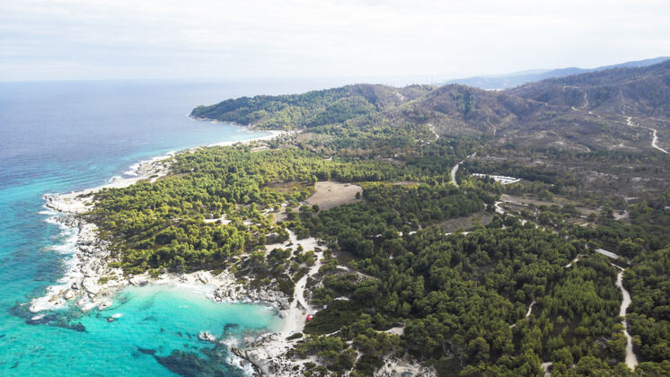 镁砂爱琴海沿岸有蓝色透明的海水 周围绿树成荫 岩石 灌木丛和树木 从无人机希腊俯瞰希腊地中海欧罗巴