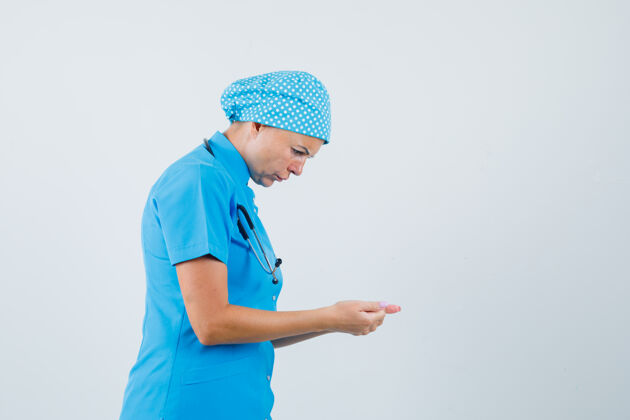 站着女医生穿着蓝色制服假装用手机 看起来很专注女人电话实验室