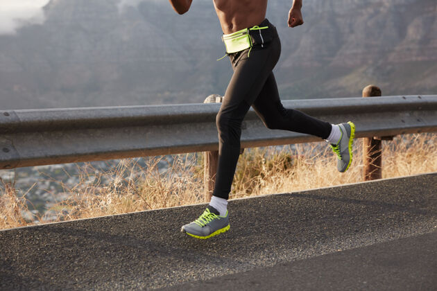 公路运动员跑步者在公路上跑步 运动中拍照 穿着舒适的运动鞋 参加马拉松专注于脚部运动员引领健康的生活方式 覆盖目的地健身鞋动机
