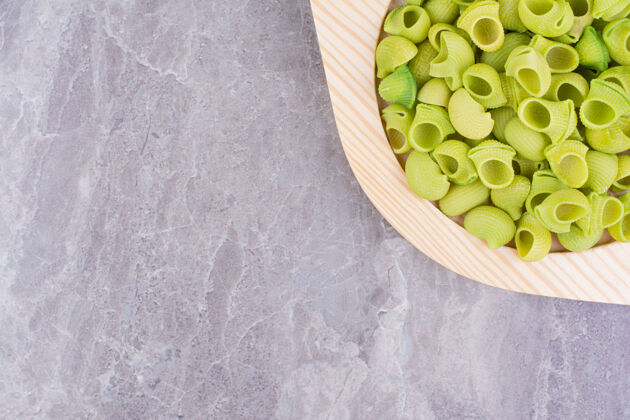 质量绿色的自制意大利面放在大理石上的盘子里生的美味食物