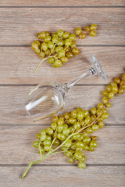 健康绿色的葡萄和一个空酒杯新鲜异国情调木材