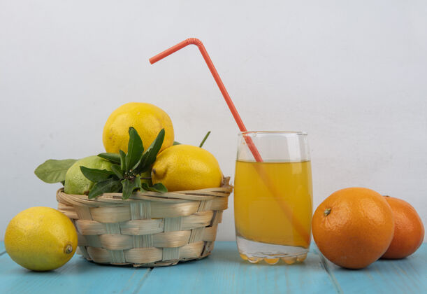 杯子正面图橙汁装在玻璃杯里 橙子和柠檬装在篮子里柠檬篮子食物