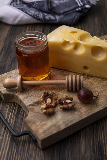 架子侧视图蜂蜜在一罐奶酪和核桃与葡萄的立场罐子奶酪甜味的