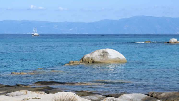 海湾爱琴海沿岸有岩石覆盖水面 船和陆地 蓝色的海水 希腊度假村镁砂海洋