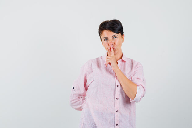 沉默女性穿着粉色衬衫 表现出沉默的姿态 看上去很小心 正面视图年轻人护士疾病