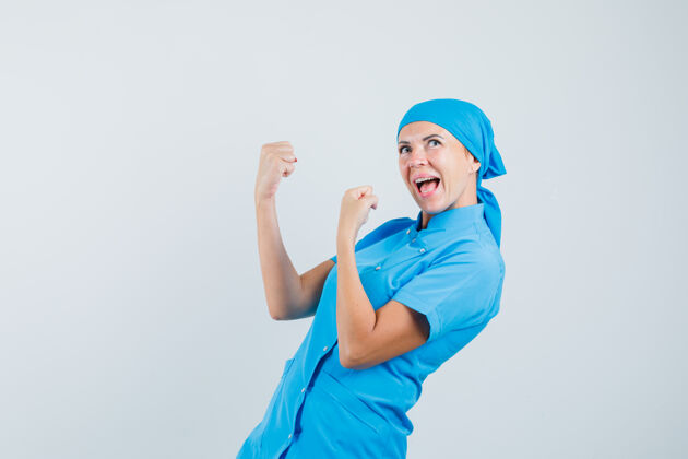 制服女医生穿着蓝色制服 摆出获胜者的姿态 看上去很开心 正面照诊所护士实验室