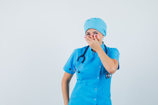 疾病女医生手放在嘴上 穿着蓝色制服 看上去很高兴正面图护士治疗病人