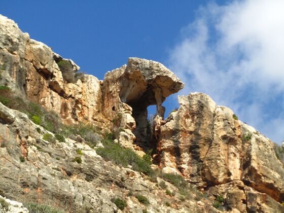 训练独特的自然岩石阴影形成的威德巴布山谷在马耳他的悬崖上蓝天草景观马耳他
