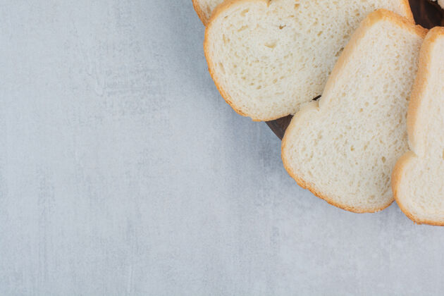 棕色大理石背景上的新鲜白面包片面包面包新鲜