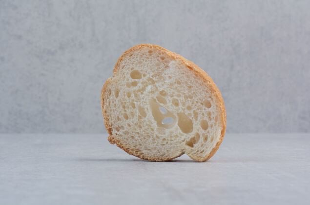 糕点在大理石背景上放一片新鲜的圆形白面包新鲜的面包片面包