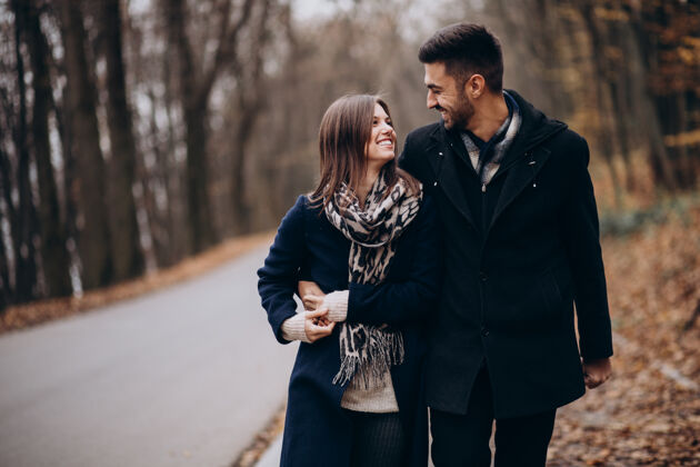 浪漫一对年轻夫妇在秋天的公园里散步调情成人年轻