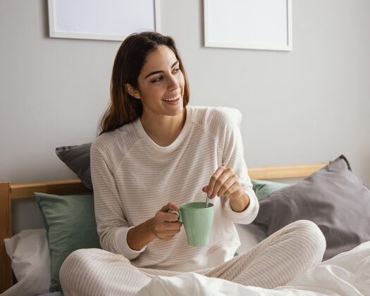 女人在床上喝咖啡的女人休息时间度假住宿