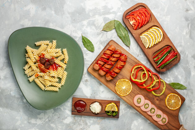 肉俯瞰美味的意大利通心粉配蔬菜和柠檬 放在浅色桌上享用意大利美食晚餐美食意大利面一餐