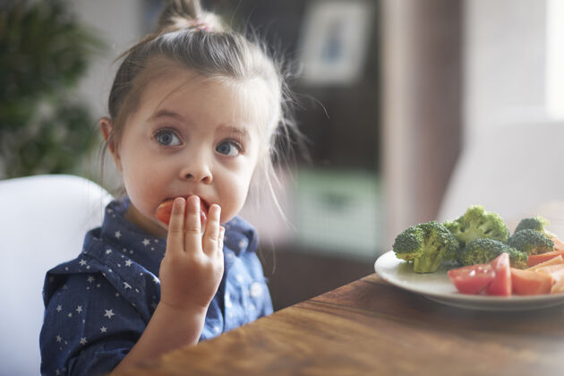 女孩小女孩在吃蔬菜餐桌孩子吃