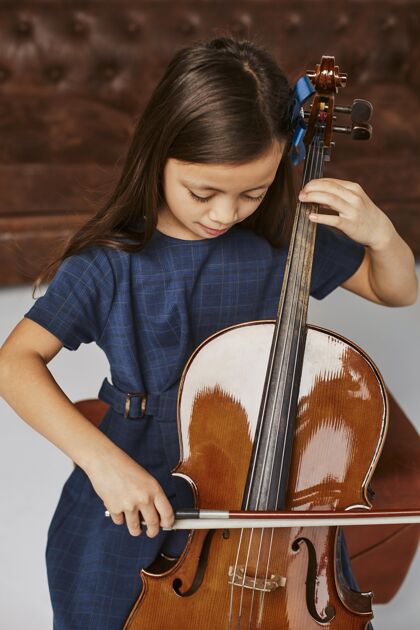 小可爱的小女孩在学大提琴表演孩子班