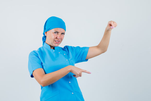 站立穿着蓝色制服的女医生假装拿着什么东西 指着下面不高兴的样子 正对着疾病不高兴假装