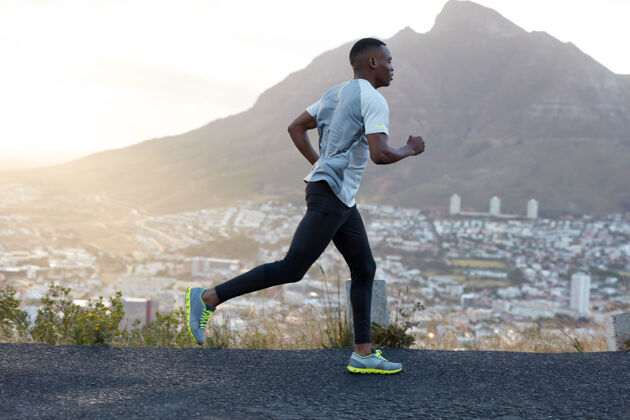 观点自信的深色皮肤运动型男性跑步者穿着运动服 长距离穿越山路 享受新鲜空气 感觉精力充沛 充满动力人 生活方式 运动理念跑步衣服慢跑
