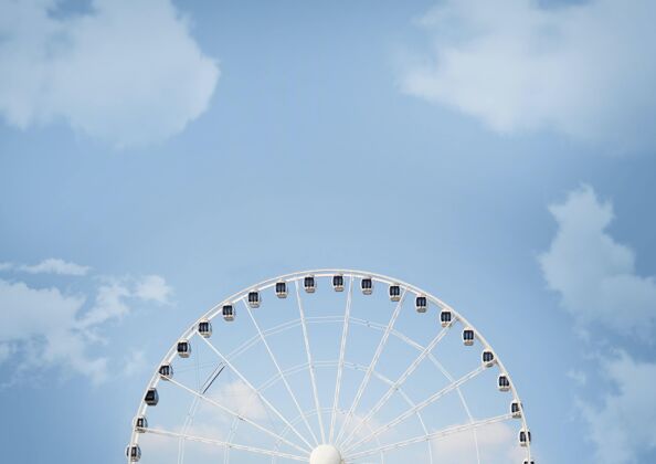 旋转木马阳光下的白色摩天轮和白天的蓝色多云天空风景快乐游乐场