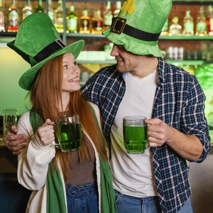 绿色笑脸男男女女在酒吧喝酒庆祝圣帕特里克节爱尔兰圣帕特里克盛宴男人