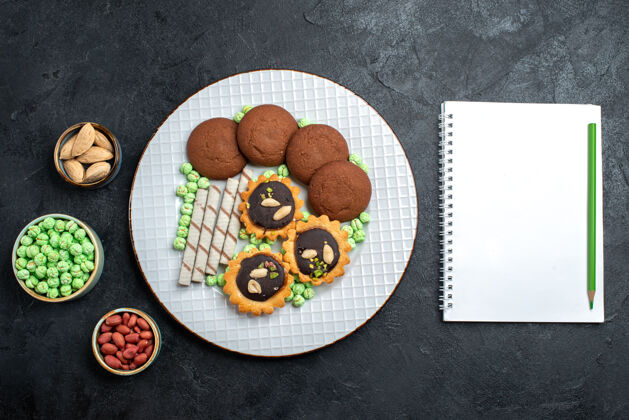 视图俯瞰美味饼干与不同的糖果在深灰色的桌子糖饼干甜蛋糕派茶饼干饼干蛋糕糖果