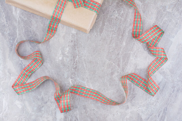 圣诞饰品大理石背景上有节日蝴蝶结的圣诞礼物圣诞弓装饰大理石