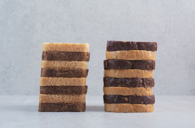 美味新鲜的白色和棕色面包片放在大理石背景上小吃棕色食品