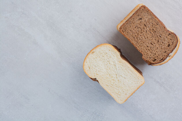 新鲜新鲜的白色和棕色面包片放在大理石背景上烘焙面包房美味