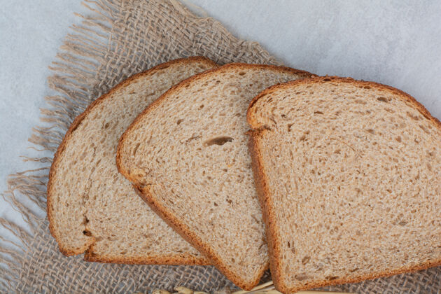面包大理石背景上的新鲜棕色面包片面包房糕点烘焙