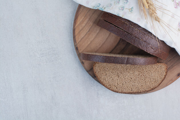 新鲜在木板上放几片新鲜的棕色面包食品切片糕点