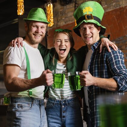 绿色快乐的人们在酒吧用饮料庆祝圣帕特里克节饮料帽子3月17日