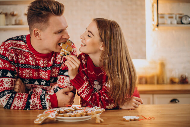 有趣夫妻俩在厨房吃圣诞饼干家庭浪漫圣诞