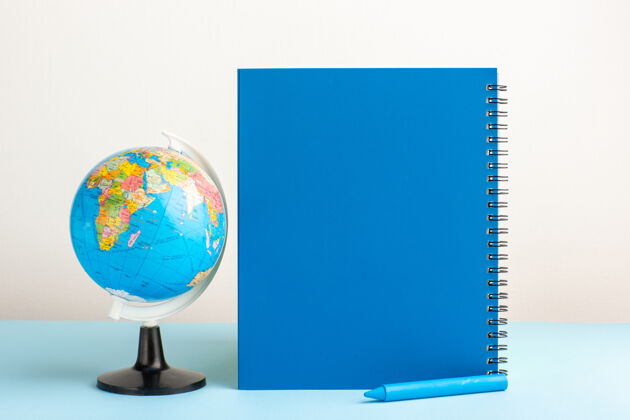 世界蓝色书桌上有蓝色复写本的地球仪行星球体发光