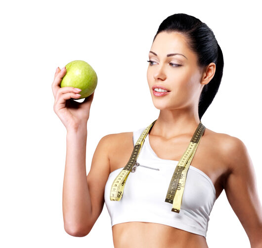 运动一个健康女人拿着苹果和一瓶水的画像健身房女性新鲜